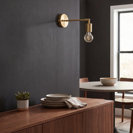 Minimalist Glass Wall Lamp swing-arm sconce above a console table, lifestyle