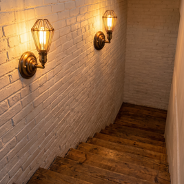 Industrial iron wall lamps lighting a staircase