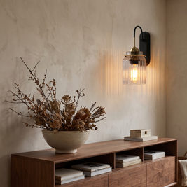 Gold wavy glass wall sconce above walnut console in living room