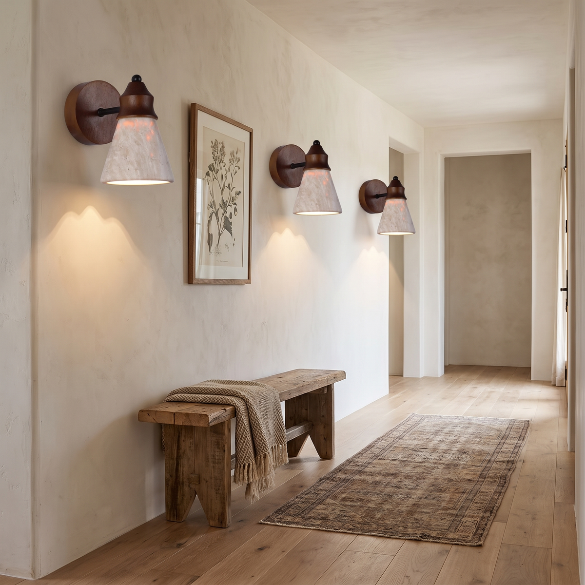 Three travertine wood sconces along a limewashed hallway