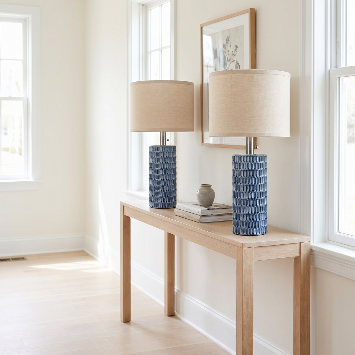 Blue ceramic lamp pair on a console in a bright white modern new-construction interior