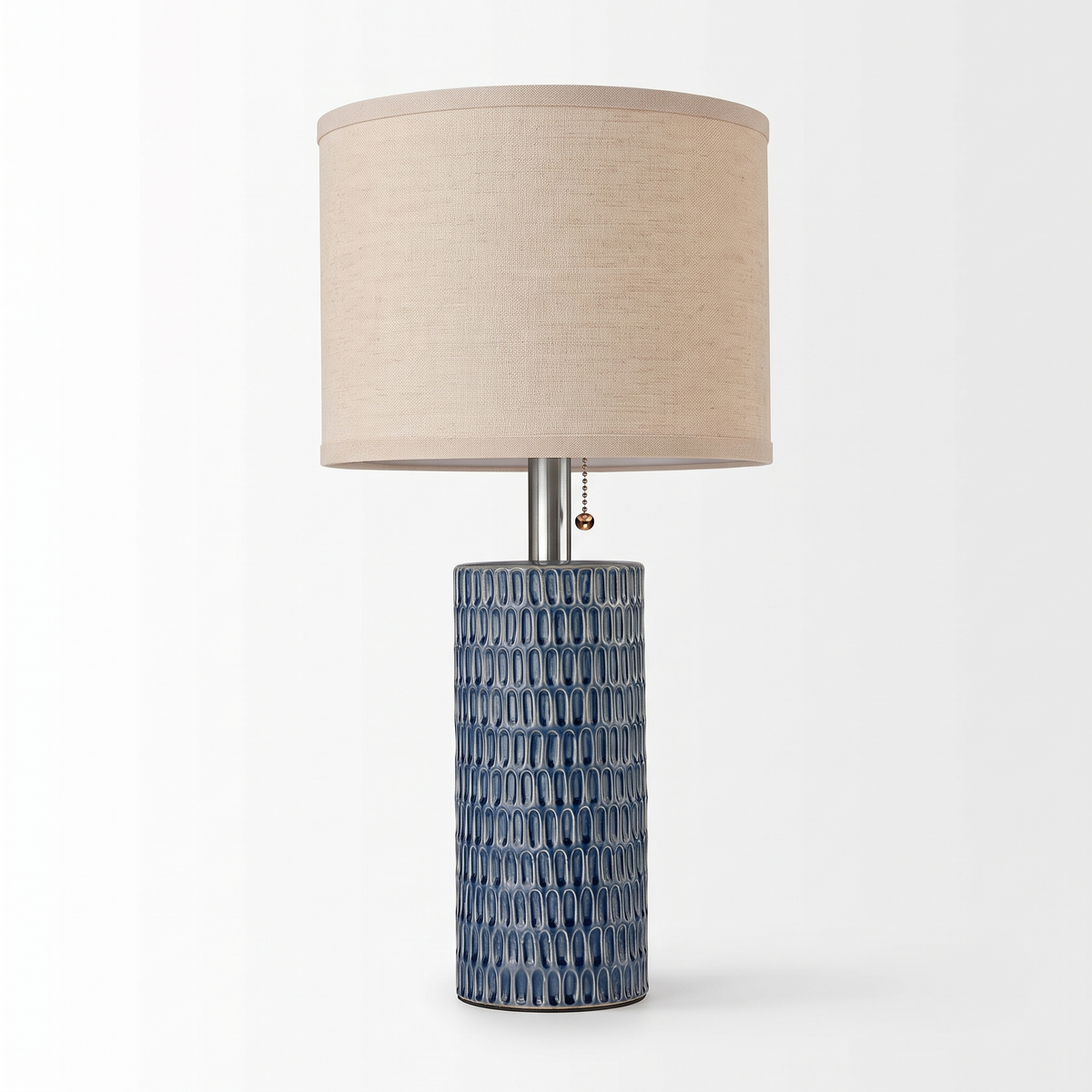 Single blue ceramic table lamp with beige linen shade centered on a pure white background