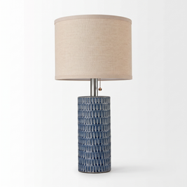 Single blue ceramic table lamp with beige linen shade centered on a pure white background