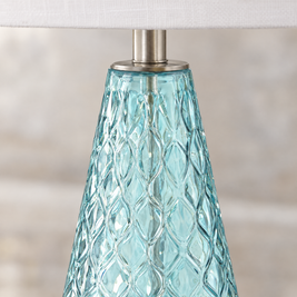 Close-up of textured diamond-pattern blue glass lamp base with brushed nickel fittings