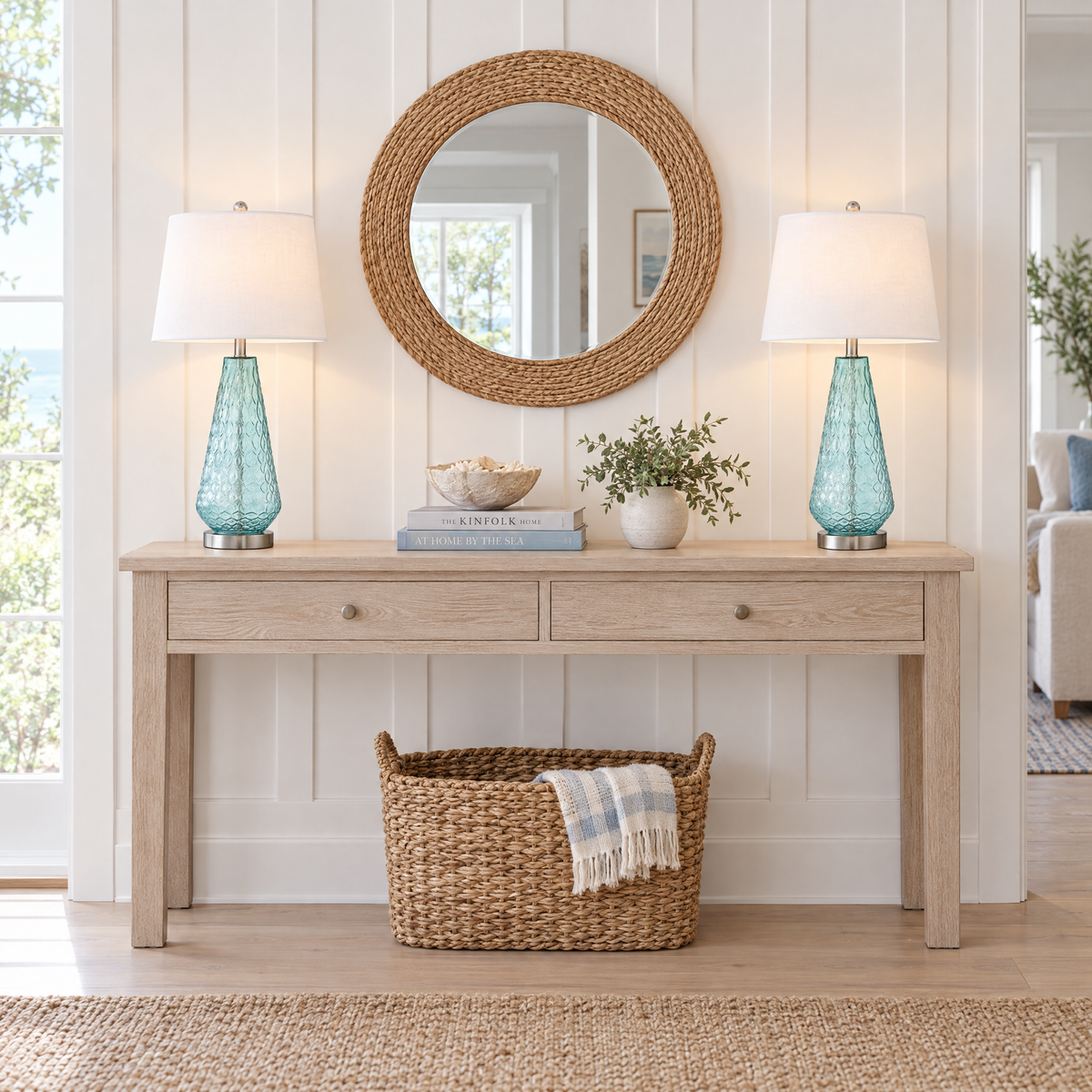 Pair of blue glass table lamps on a whitewashed console table in a modern coastal entryway