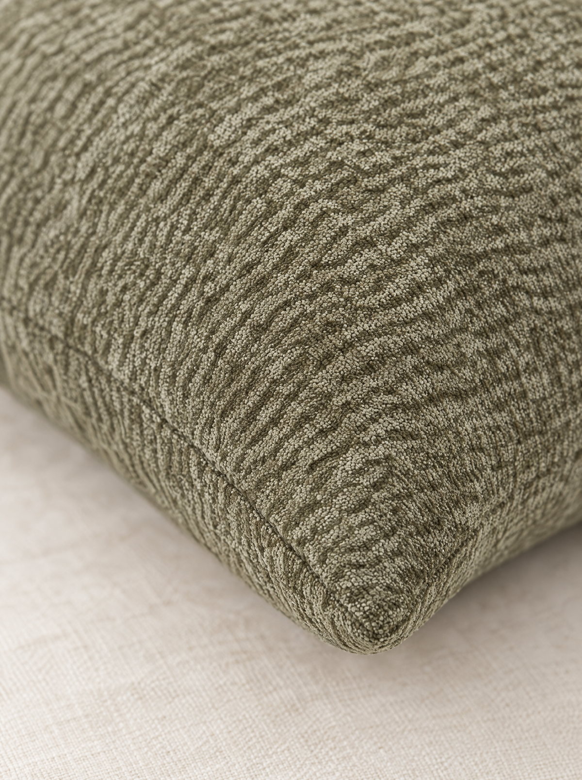 Close-up of the dark sage textured jacquard weave and knife-edge seam