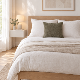 Dark sage jacquard pillow cover on a white linen bed in a Scandinavian bedroom